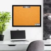 A laptop and monitor on a desk in front of a picture.